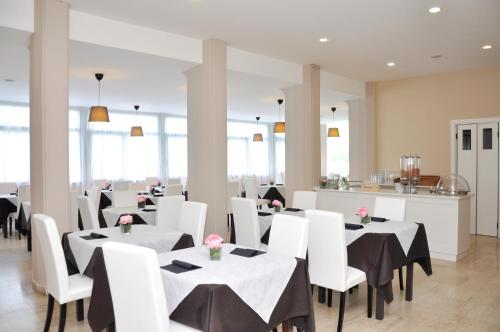 a dining room with white tables and white chairs at Hotel Airone in Marina di Pietrasanta