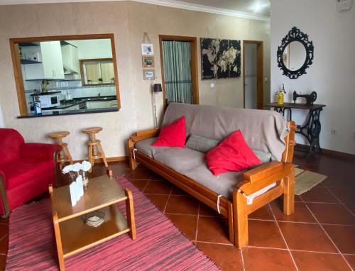 uma sala de estar com um sofá e almofadas vermelhas em BEACH-SURF house em Moledo