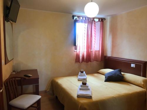 a bedroom with a bed and a table and a window at Locanda della Corte in Roccamorice