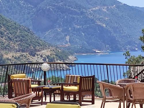 a balcony with chairs and tables and a view of a lake at Belle Vue Ölüdeniz in Fethiye