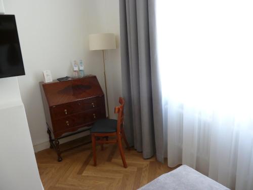 a room with a chair and a dresser and a lamp at Hotel Lindenufer in Berlin
