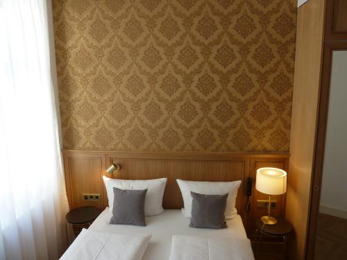 a bedroom with a white bed and a wall at Hotel Lindenufer in Berlin