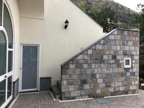a house with a stone wall next to a door at Casale Guarracino in Sant'Agnello