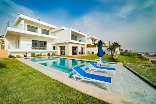 a villa with a swimming pool and a house at Villa Agadir Taghazout Bay Beach & Golf View in Taghazout