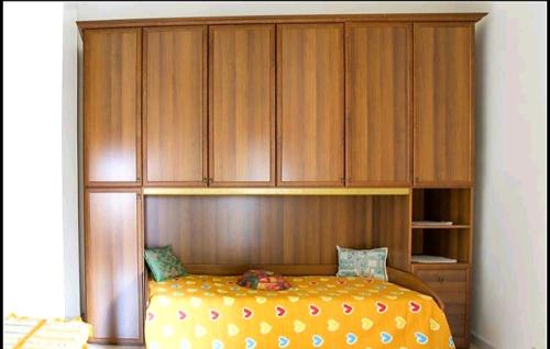 a bedroom with a bed with wooden cabinets at CASA VACANZA BariSardo in Bari Sardo