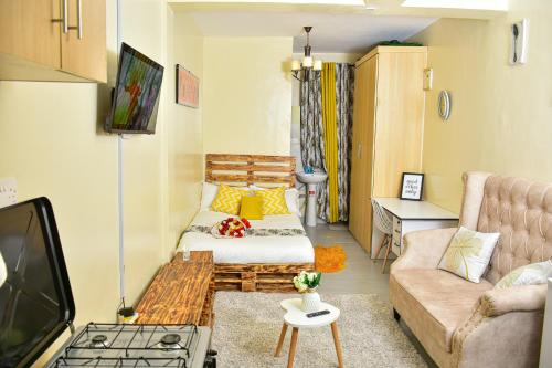 a living room with a couch and a tv at Ruby Modern Homes Studio Apt-Imara Daima Behind Imaara Mall-JKIA-Nebula in Nairobi