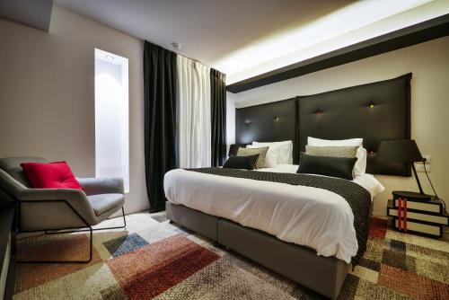 a bedroom with a large bed and a chair at 21st Floor Hotel in Jerusalem