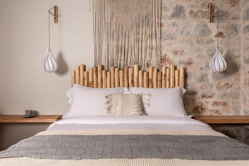 a bed with a wooden headboard in a bedroom at The Olive Yard in Gythio