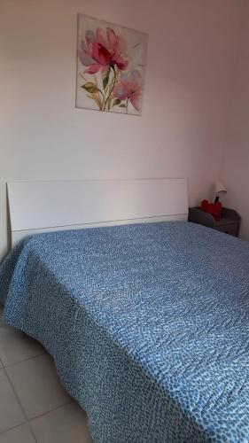 a bed with a blue comforter in a bedroom at Il Gelso in Pimonte