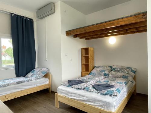 a bedroom with two beds and a loft bed at Pisztráng17 Apartman in Gárdony