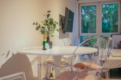 沙莫林的住宿－Residence Šamorín，白色的桌子和椅子,上面有花瓶