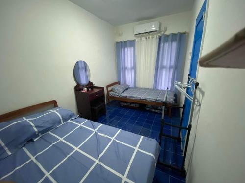 a bedroom with a bed and a bench in it at Bayabas,DigFamilyApartment Fully Furnished Near Tandag City in Somosomo