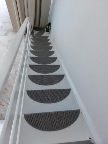 a stairway with black treads in a white room at Nefeli Seaside Apartments in Polykhrono