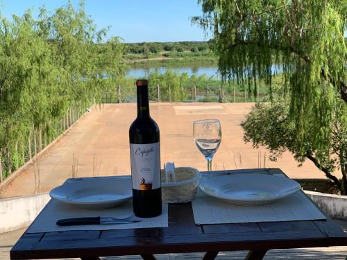 a bottle of wine sitting on a table with a glass at CostaMansa House, a orillas del Rio Paraguay in Asuncion