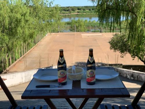 two bottles of beer sitting on a wooden table at CostaMansa House, a orillas del Rio Paraguay in Asunción