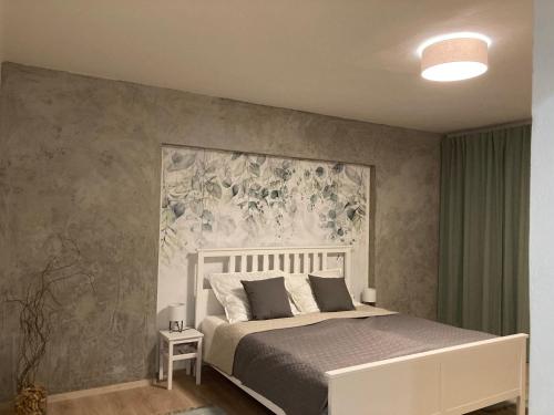 a bedroom with a bed with a floral mural on the wall at Family Provence Mikulov in Mikulov