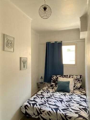 - une chambre avec un lit doté d'un rideau bleu dans l'établissement Le Balzac - Cannes, à Cannes