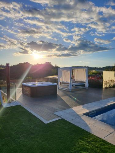 a backyard with a hot tub on a deck at Villa Moura - Pool & Jacuzzi in Póvoa de Lanhoso