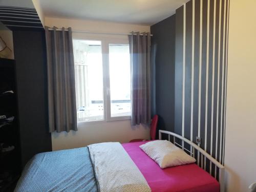 a small bedroom with a bed and a window at RiView in Rijeka