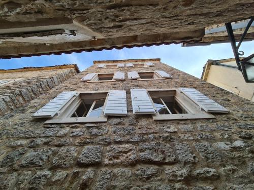 three windows on the side of a stone building at Beatrix Suites in Budva