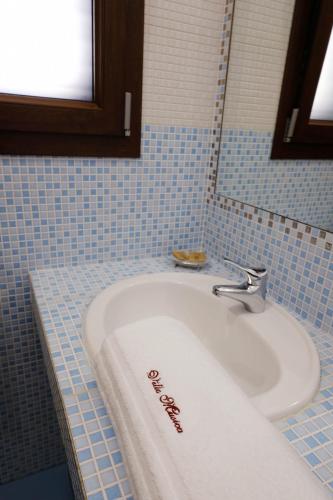 a bathroom with a white towel on a sink at Villa Musica in Sannicola