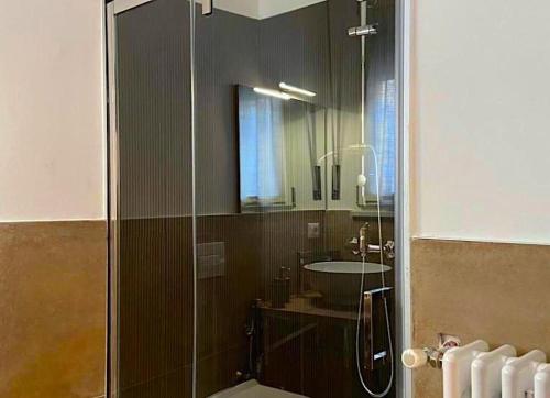 Un baño con ducha de cristal y lavabo. en Fenì Home, en Tricarico