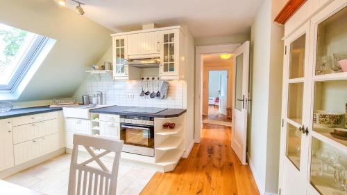 a kitchen with white cabinets and a stove top oven at Luxuriöses Apartment mit Parkplatz - Klimaanlage -Netflix in Coburg