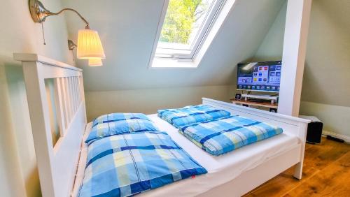ein Schlafzimmer mit einem Bett mit zwei Kissen und einem Fernseher in der Unterkunft Luxuriöses Apartment mit Parkplatz - Klimaanlage - nahe Klinikum in Coburg