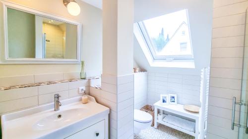 ein weißes Badezimmer mit Waschbecken und Toilette in der Unterkunft Luxuriöses Apartment mit Parkplatz - Klimaanlage - nahe Klinikum in Coburg