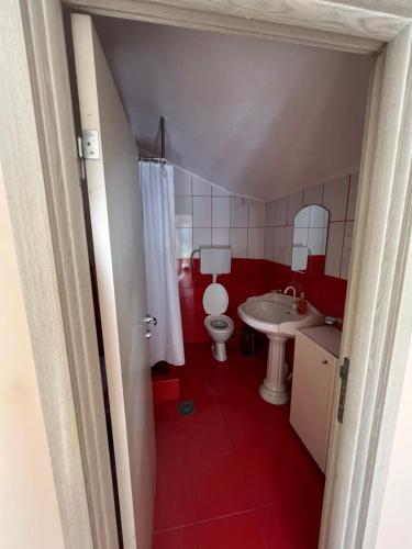 ein rotes Badezimmer mit WC und Waschbecken in der Unterkunft Apartman Savo in Kotor
