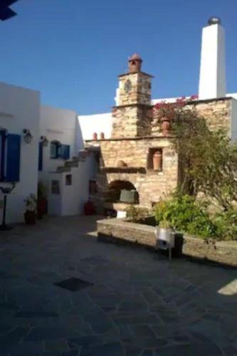 ein Steingebäude mit einem Leuchtturm im Hintergrund in der Unterkunft Apartment in the center of Artemonas, Sifnos in Artemonas