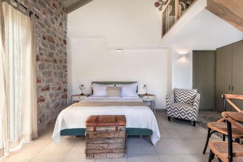 a bedroom with a bed and a brick wall at The Olive Yard in Gythio