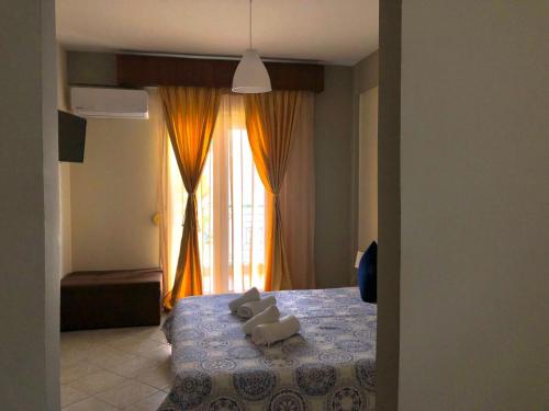 a bedroom with a bed with two stuffed animals on it at VASILEVI STUDIOS in Nea Kalikratia