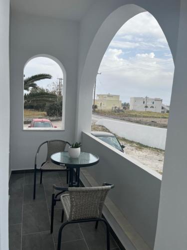 een balkon met een tafel en stoelen en een raam bij Ether in Perivolos
