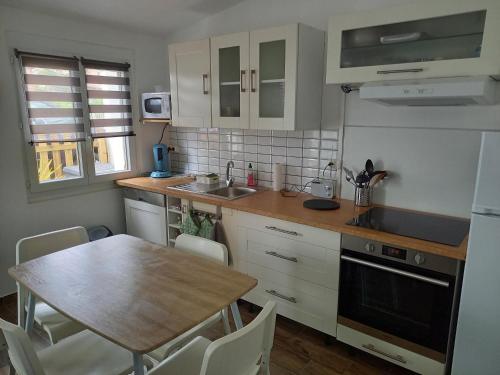 une cuisine avec une table en bois et une table et des chaises dans l'établissement Maison de pêcheur à 2 pas de la mer (200m), à Bretignolles-sur-Mer