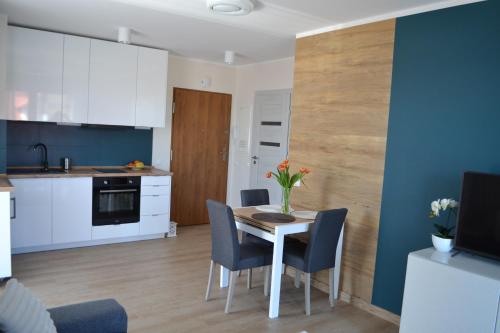 a kitchen and dining room with a table and chairs at Apartament Justynka in Kąty Rybackie