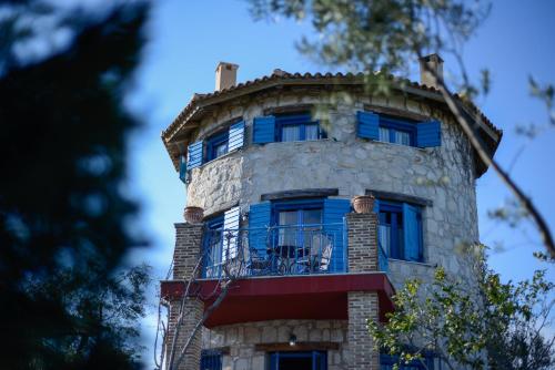 un edificio con finestre blu e balcone di Valory's Houses - The Tower a Vasilikós