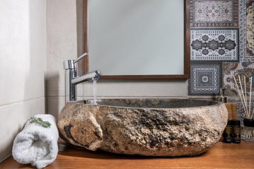 a large rock sink in a bathroom with a towel at The Olive Yard in Gythio