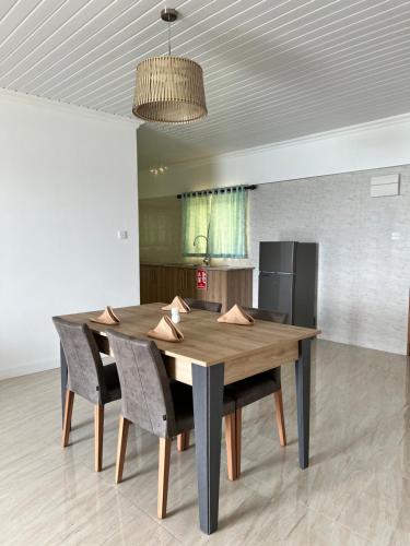 a dining room table with chairs and a kitchen at Western Ocean Breeze Self Catering in Victoria