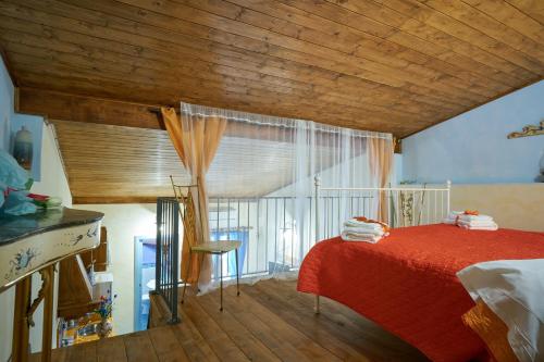 1 dormitorio con cama roja y ventana en Ambra di mare, en SantʼAgata di Militello