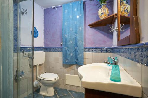 a bathroom with a toilet and a sink and a shower at Ambra di mare in SantʼAgata di Militello