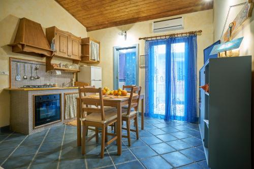 a kitchen with a table and chairs and a refrigerator at Ambra di mare in SantʼAgata di Militello