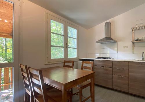 a kitchen with a wooden table and some chairs at Camping Village la Verna in Chiusi della Verna