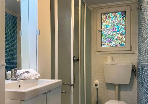 a bathroom with a sink and a toilet and a window at Camping Village la Verna in Chiusi della Verna