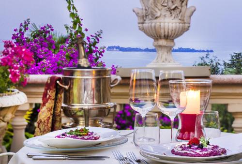 a table with plates of food and wine glasses at Park Hotel Ville Montefiori in Gardone Riviera