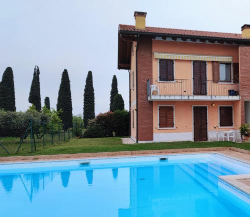 une villa avec une piscine en face d'une maison dans l'établissement Casa Dolcitalia a Gardaland con piscina, à Ronchi