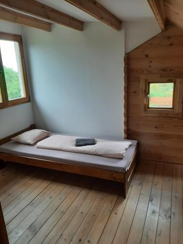 1 dormitorio con 1 cama en una habitación con suelo de madera en Domek Brno - Nový lískovec en Brno