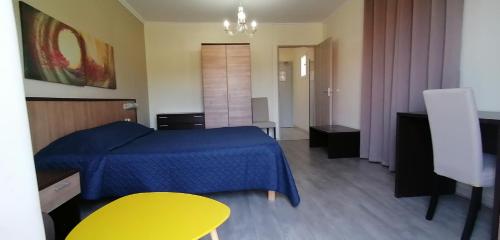 um quarto com uma cama azul e uma mesa amarela em U Libecciu em Macinaggio