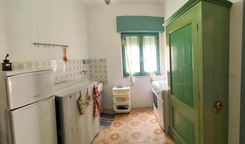 kuchnia z zielonymi drzwiami i umywalką w obiekcie Casa Vacanze Else w mieście Lazzaro