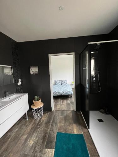 a bathroom with black walls and a bed in the doorway at Maison de fanny in Riscle